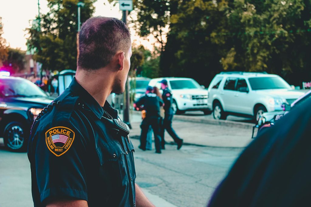police officer overlooking scene of arrest of property crime suspect