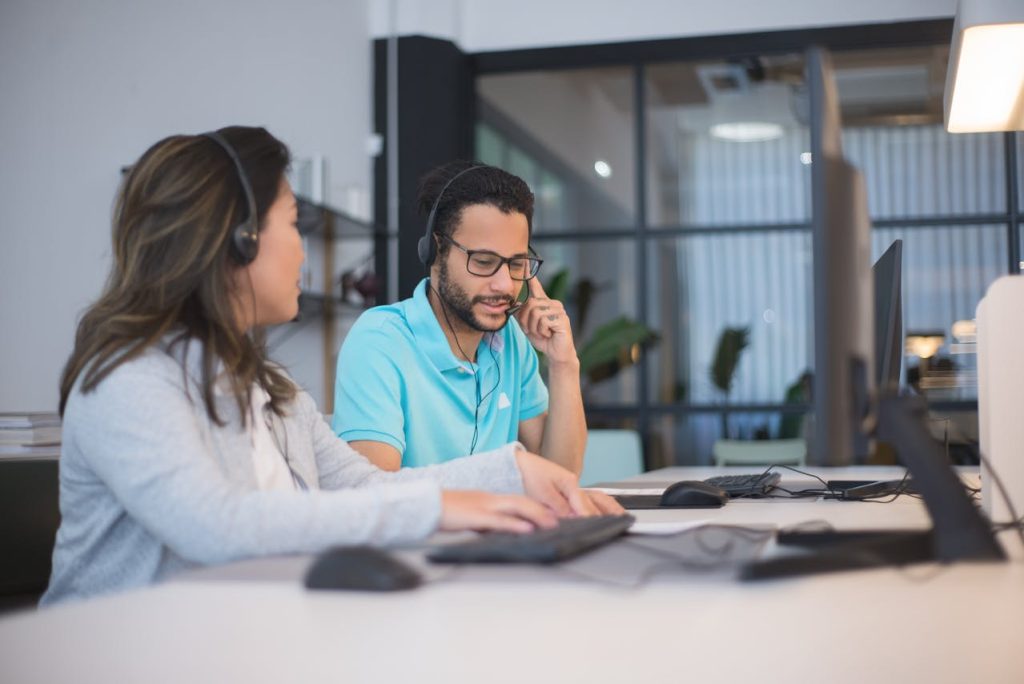 two corporate employees discussing a transaction made using digital identity fraud