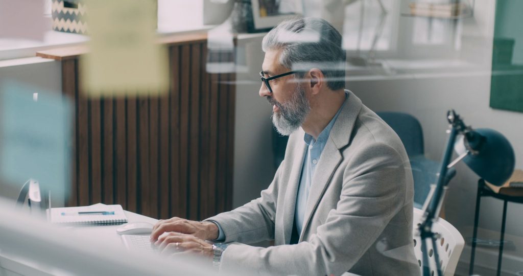 alt tag: man working on computer to improve insurance claims handling process